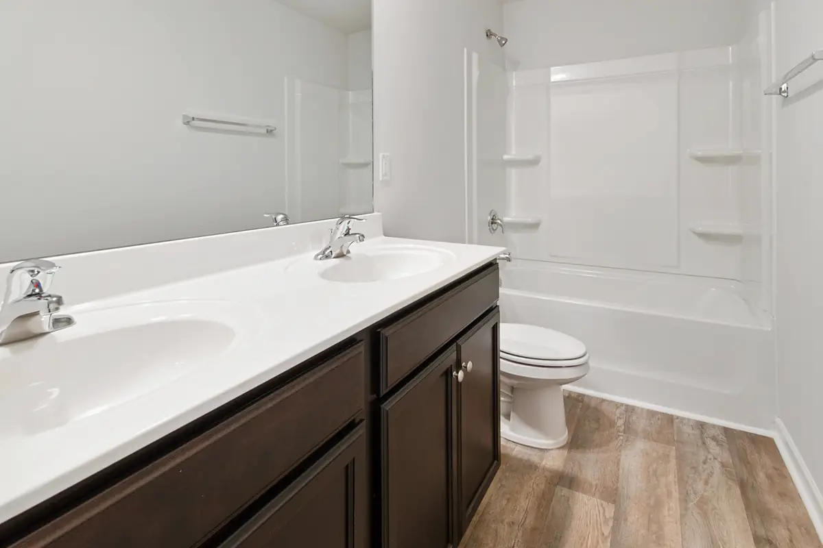 White bathroom shower and vanity area with tub, mirror, and clean wall surfaces