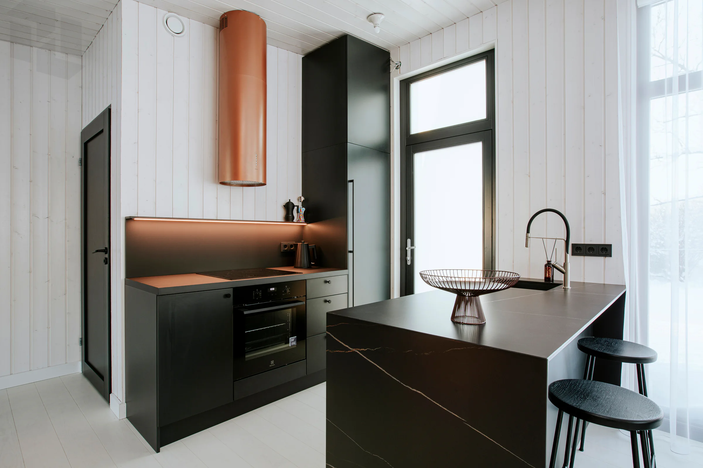 Finished kitchen remodel with island, cabinetry, counters, lighting, and appliance wall