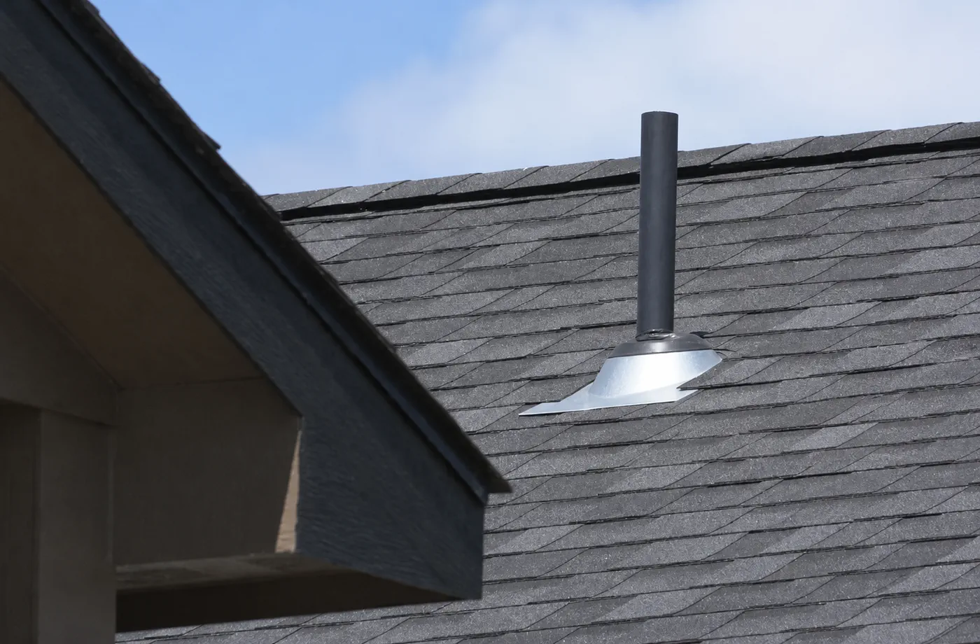 Finished low-slope membrane roof section with clean edge metal on a Wisconsin home