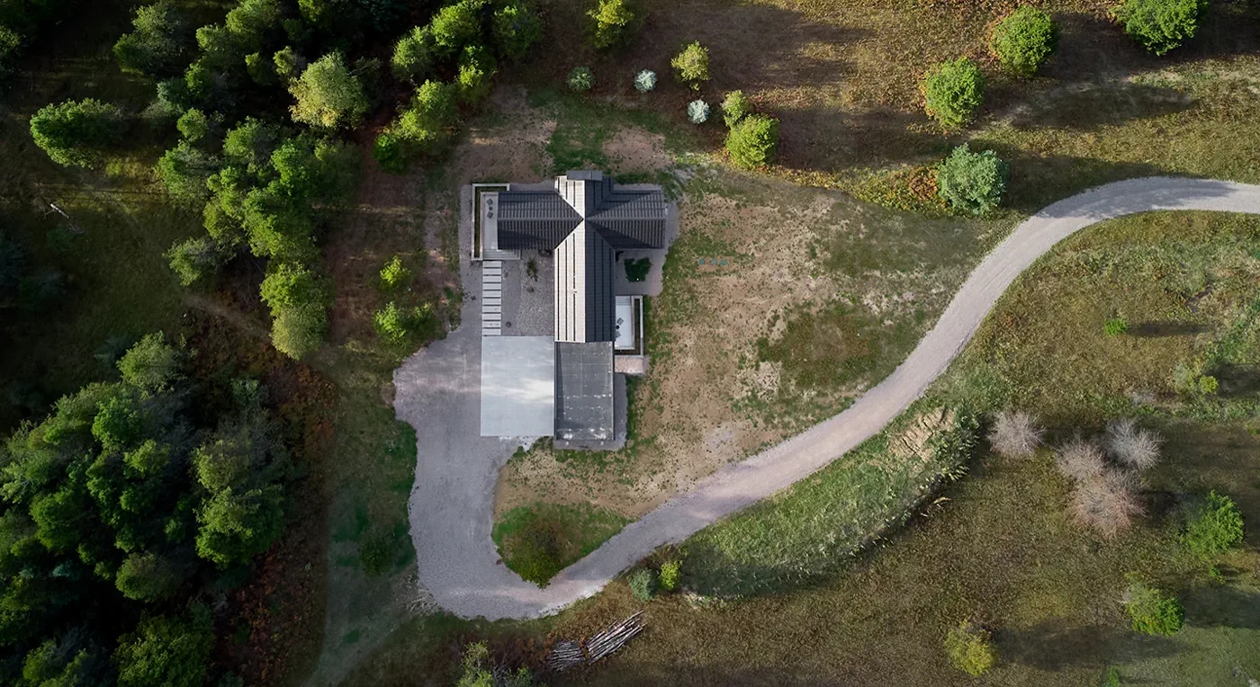 Aerial view of wooded roof site with driveway access and roof geometry planning context